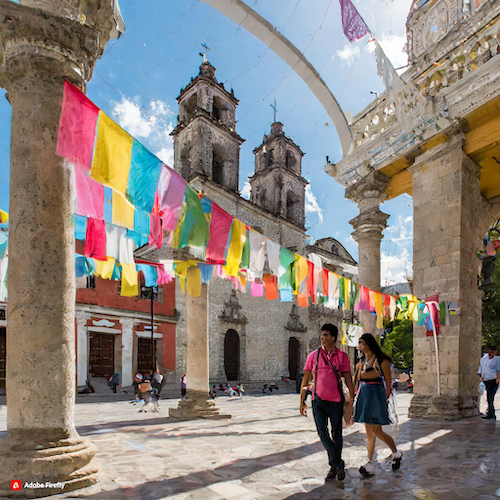  Firefly Church plaza in Guadalajara , Mexico with people walking and laughing and colorful banners